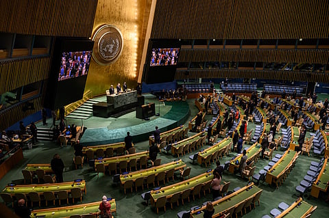 (FILE PHOTO) Attendees of a General Assembly meeting stand in silence during a tribute to Britain's Queen Elizabeth, at the United Nations headquarters in New York on 15 September 2022. After two years of pandemic restrictions and video addresses, the UN General Assembly is again asking leaders to come in person if they wish to speak.