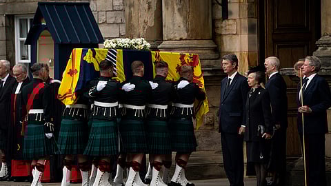 Vice Admiral Timothy Laurence (fifth from right), Britain’s Princess Anne, the Princess Royal (fourth from right), Britain’s Prince Andrew, Duke of York, (third from right) and Britain’s Prince Edward, Earl of Wessex (second from right) stand as the coffin of Queen Elizabeth II, draped with the Royal Standard of Scotland, is carried into the Palace of Holyroodhouse,in Edinburgh Sunday. The coffin carrying the body of Queen Elizabeth II left her beloved Balmoral Castle on Sunday, beginning a six-hour journey to the Scottish capital of Edinburgh. | Aaron Chown / POOL/AGENCE FRANCE-PRESSE