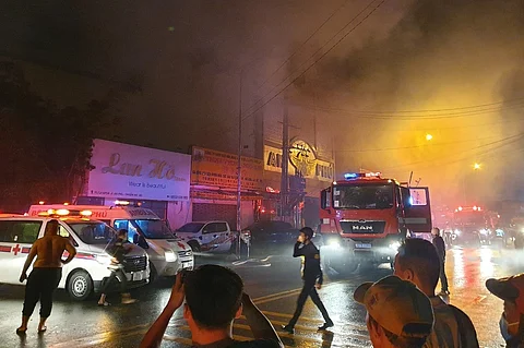 (FILES) This picture taken on 6 September 2022 and released on 7 September by the Vietnam News Agency shows firefighters at the scene of a deadly fire that engulfed a karaoke bar in Binh Duong province, north of Ho Chi Minh City, killing 12 people and leaving 11 injured.