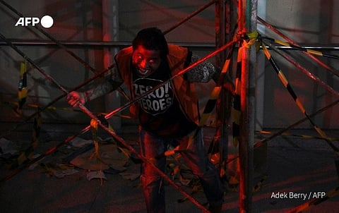 Jakarta's light rapid transit operator has turned a train and station into the set of a bloody zombie apocalypse -- with real passengers invited to the show. (Photo by ADEK BERRY / AFP)