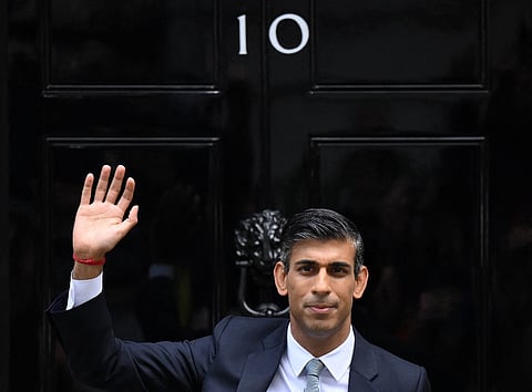 Britain's newly appointed Prime Minister Rishi Sunak waves as he poses outside to door to 10 Downing Street in central London, on October 25, 2022, after delivering his first speech as prime minister. - Rishi Sunak was on Tuesday appointed as Britain's third prime minister this year, after outgoing leader Liz Truss submitted her resignation to King Charles III. Photo by Daniel LEAL / AFP