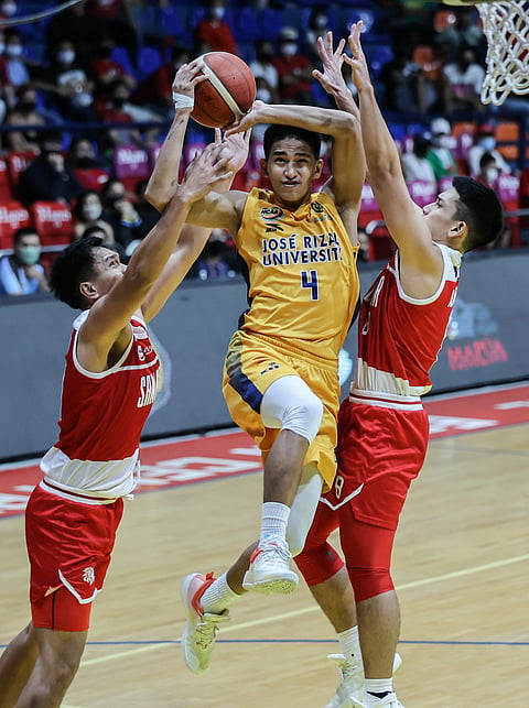 Photograph by Rio Deluvio
for the Daily Tribune @tribunephl_rio
AGEM Miranda of JRU attacks the defense of Damie Cuntapay (left) and Peter Alfaro of San Beda during their Season 98 NCAA men’s basketball tournament game yesterday. The Heavy Bombers won, 83-80.