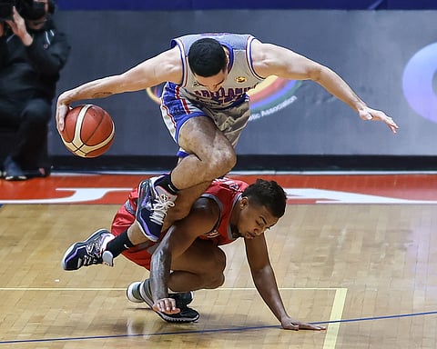 Cade Flores of Arellano jumps over Omar Larupay of Lyceum during their Season 98 NCAA men’s basketball tournament game on Tuesday. Photo by Rio Deluvio