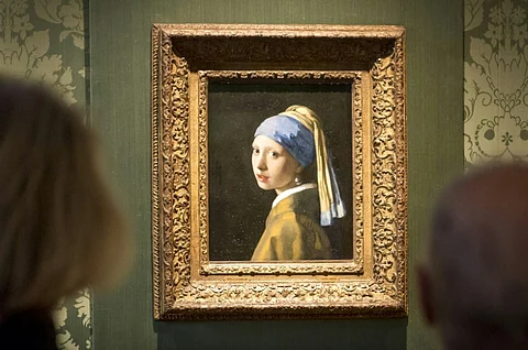 Johannes Vermeer's masterpiece 'Girl with a Pearl Earring' was targeted by climate activists, with two activists gluing themselves to the painting and adjoining wall, and another throwing a thick red substance. But the artwork was behind glass and undamaged. (Photo by WANG ZHAO / AFP)