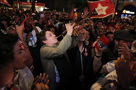 Supporters of Brazilian former President Luiz Inacio Lula da Silva react as they watch the vote count of the legislative and presidential election, in Sao Paulo, Brazil, on 2 October 2022. Brazil's bitterly divisive presidential election will go to a runoff on 30 October, electoral authorities said Sunday, as incumbent Jair Bolsonaro beat expectations to finish a relatively close second to front-runner Lula da Silva. (Photo by CAIO GUATELLI / AFP)