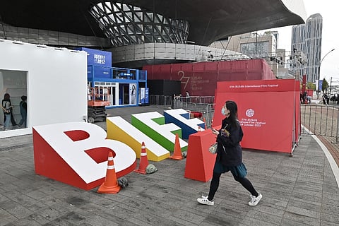 A woman walks past an installation for the 27th Busan International Film Festival at the Busan Cinema Center in Busan on 5 October 2022. (Photo by JUNG YEON-JE / AFP)