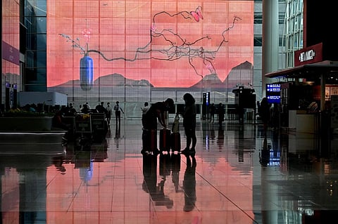 In this file photo, travelers arrive at Hong Kong's international airport on 27 September 2022. The city, which only scrapped mandatory quarantine for international arrivals last month, is set to end the year in full-blown recession and has seen its fiscal deficit soar. (Photo by PETER PARKS / AFP)