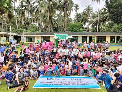 Del Pilar Elementary School students and Malayan representatives share a light moment during the ‘Sales Cares’ turnover. | Photograph courtesy of Malayan Insurance