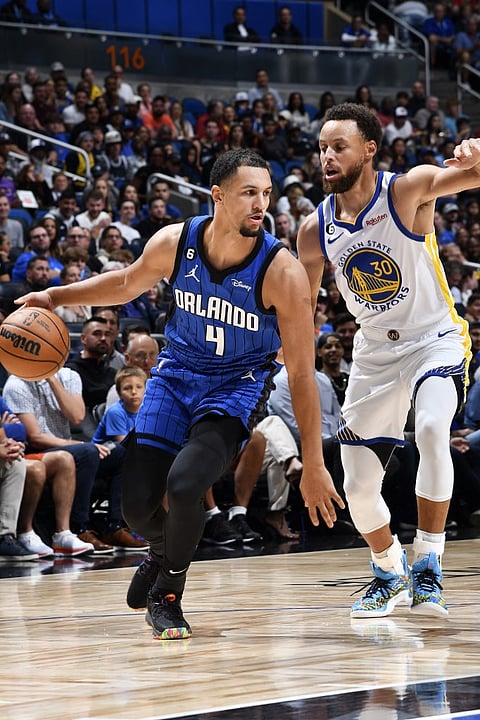 Jalen Suggs of the Orlando Magic handles the ball during the game against the Golden State Warriors, Stephen Curry #30 of the Golden State Warriors plays defense on November 2, 2022 at Amway Center in Orlando, Florida. Photo by Fernando Medina / NBAE / Getty Images / Getty Images via AFP