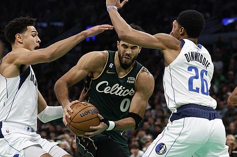 Jayson Tatum of the Boston Celtics tries to get between Spencer Dinwiddie of the Dallas Mavericks and Josh Green during the second quarter Photo By Winslow Townson/Getty Images