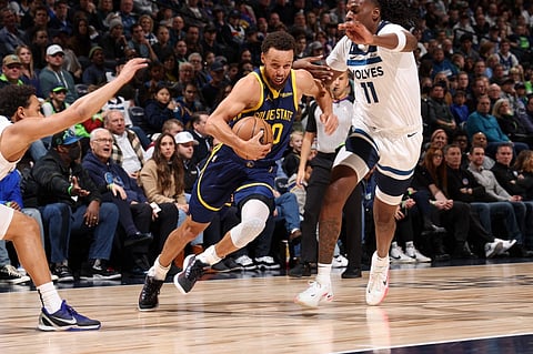 Stephen Curry of the Golden State Warriors drives to the basket during the game against the Minnesota Timberwolves on November 27, 2022 at Target Center in Minneapolis, Minnesota. Photo by David Sherman / NBAE / Getty Images / Getty Images via AFP