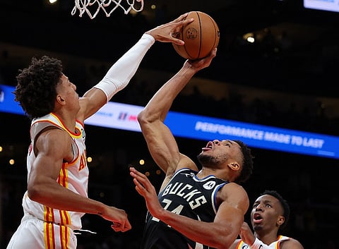Jalen Johnson of the Atlanta Hawks blocks a shot by Giannis Antetokounmpo of the Milwaukee Bucks during the second half. Photo by Kevin C. Cox / GETTY IMAGES NORTH AMERICA / Getty Images via AFP
