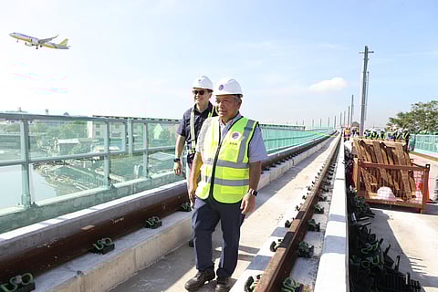 Transportation Secretary Jaime Bautista (right) and Light Rail Manila Corporation president and CEO Juan Alfonso inspect the LRT-1 Cavite Extension Phase 1 project on Monday along C5 Extension in Las Piñas City. | Photograph by Joey Sanchez Mendoza for the daily tribune @tribunephl_joey