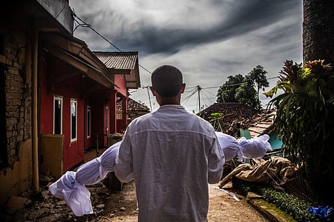 A villager carries the body of his dead son following a 5.6-magnitude earthquake that killed at least 162 people, with hundreds injured and others missing in Cianjur, Indonesia, on 22 November 2022. (Photo by ADITYA AJI / AFP)
