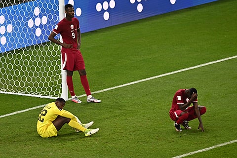 Qatari players look dejected after losing to Senegal, 2-1, and crashing out of the World Cup in Doha. | MANAN VATSYAYANA/AGENCE FRANCE-PRESSE