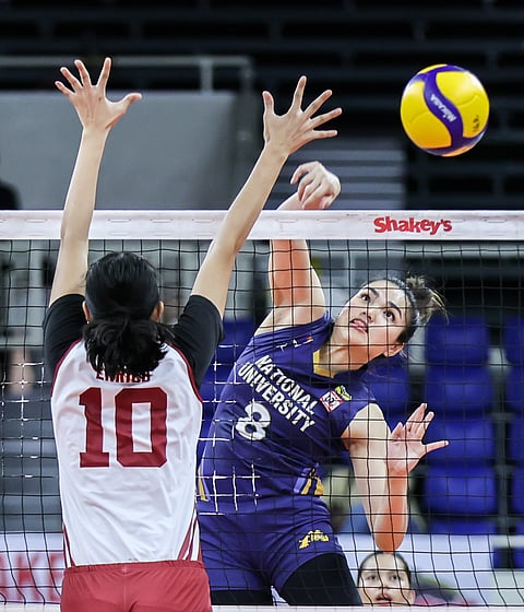 Sheena Toring of National University scores against Charice Enrico of Perpetual Help yesterday in the Shakey’s Super League at the Rizal Memorial Stadium. The Lady Bulldogs won, 25-17, 25-7, 25-17. / Rio deluvio