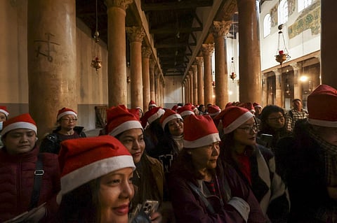 Tourists and pilgrims visit the Church of the Nativity in the biblical West Bank city of Bethlehem on December 24, 2022. Photo by HAZEM BADER / AFP