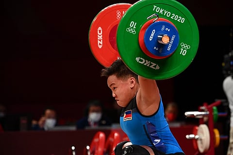 FILE PHOTO: Philippines' Elreen Ann Ando competes in the women's 64kg weightlifting competition during the Tokyo 2020 Olympic Games at the Tokyo International Forum in Tokyo on July 27, 2021. Photo by Vincenzo PINTO / AFP