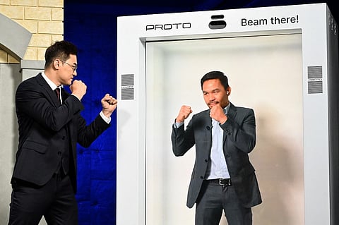 DK Yoo faces off with Manny Pacquiao who appeared in a hologram during a press conference on 13 October. Photo by John MCCOY / GETTY IMAGES NORTH AMERICA / Getty Images via AFP