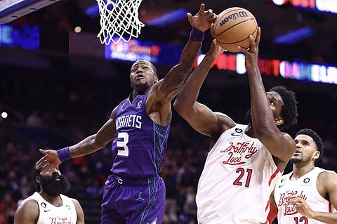 Terry Rozier of the Charlotte Hornets and Joel Embiid of the Philadelphia 76ers reach for a rebound during the fourth quarter at Wells Fargo Center. Photo by Tim Nwachukwu / GETTY IMAGES NORTH AMERICA / Getty Images via AFP