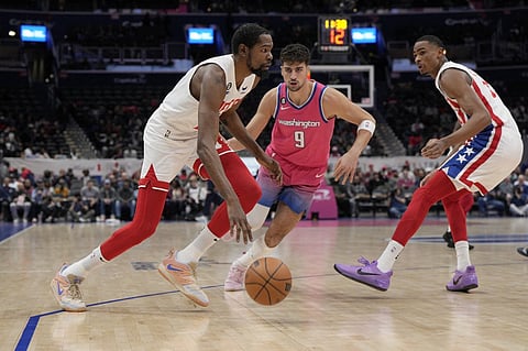 Kevin Durant of the Brooklyn Nets dribbles as Deni Avdija of the Washington Wizards defends during the first half. Photo by Jess Rapfogel / GETTY IMAGES NORTH AMERICA / Getty Images via AFP