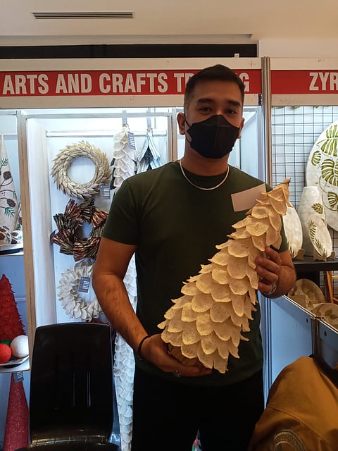 Ginno Desiacamento (left), owner of Ginnto Arts and Crafts Trading, with a table Christmas tree made of abaca.