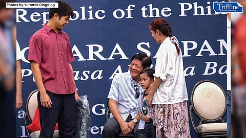 President Ferdinand Marcos Jr. (center) with an OFW family at the "Pamaskong Handong Para sa Pamilyang OFW” program at the Malacanang Palace grounds on Friday, 30 December 2022. (Photo by Yummie Dingding)