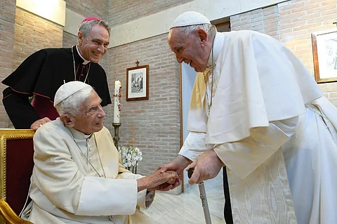 This file photo taken 27 August 2022 by the Vatican Media shows Pope Francis (right) with Pope Emeritus Benedict XVI (left) and Benedict XVI's aide Georg Gaenswein. (Photo by VATICAN MEDIA / AFP)