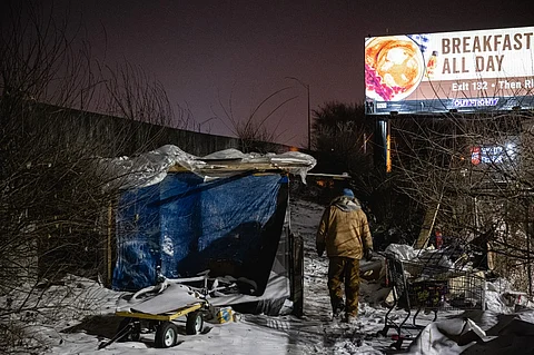 An outreach worker delivers supplies to people living in a homeless camp on 23 December 2022 in Louisville, Kentucky. (Photo by Jon Cherry / GETTY IMAGES NORTH AMERICA / Getty Images via AFP)
