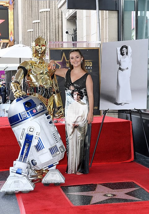 Actress Billie Lourd poses with Star Wars character R2D2 and C3PO during the ceremony for her mother Carrie Fisher being honored posthumously with a Star on the Hollywood Walk of Fame on 4 May 2023 in Hollywood, California. (Photo by VALERIE MACON / AFP)