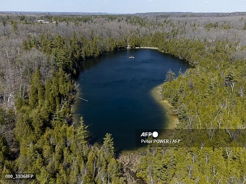 FILE PHOTO: An aerial view of Crawford Lake as a team consisting of scientists from Carleton University and Brock University gather sediment layer samples from the lake bottom at the Crawford Lake Conservation Area near Milton, Ontario, Canada, 12 April 2023. (Photo by Peter POWER / AFP)