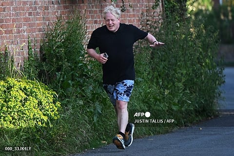 FILE PHOTO: Former British Prime Minister Boris Johnson leaves his house for a run in Brightwell-cum-Stowell, west of London on 14 June 2023. (Photo by JUSTIN TALLIS / AFP)