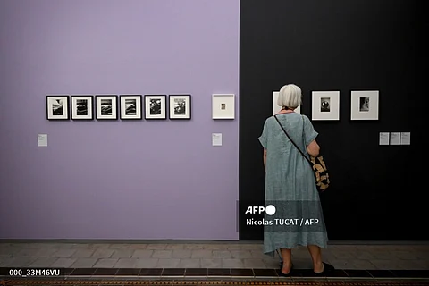A visitor looks at photographs from the exhibition "Assemblage" by US artist Saul Leiter on the opening day of "Les Rencontres d'Arles" photography festival in Arles, southern France, on 3 July 2023. (Photo by Nicolas TUCAT / AFP)