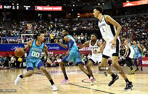 Charlotte Hornets' Nick Smith Jr. (L) holds the ball as San Antonio Spurs' Victor Wembanyama (R) guards him during the NBA Summer League game between the San Antonio Spurs and Charlotte Hornets, at the Thomas and Mack Center in Las Vegas, Nevada, on July 7, 2023. Photo by Patrick T. Fallon / AFP