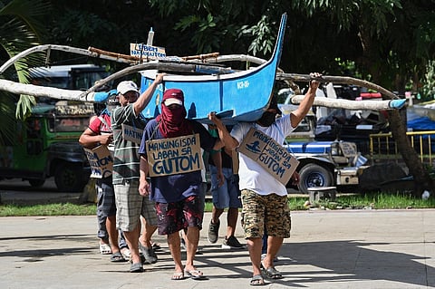 FILE PHOTO: Filipino fishermen, who say they face harassment from Chinese vessels preventing them from entering prime fishing waters in the South China Sea's Scarborough Shoal which is claimed by both countries, demonstrate at a park in Manila on 24 November 2022. (Photo by Ted ALJIBE / AFP)