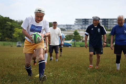 FILE PHOTO: This photo taken on 28 June 2023 shows 85-year-old rugby player Yasutake Oshima (L) taking part in a rugby training session for his senior over 70s team, at the Fukasawa Multi-Purpose Sports Plaza in Kamakura, Kanagawa prefecture. (Photo by KAREN HAIBARA / AFP)
