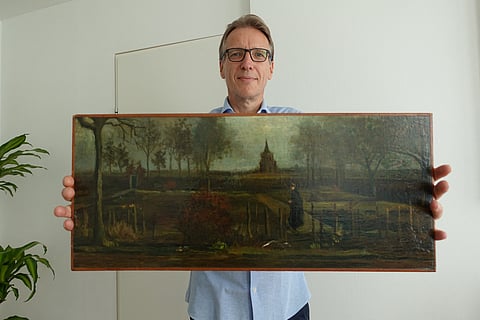 A handout picture released by Dutch art detective Arthur Brand shows a portrait of him posing with the painting title "Parsonage Garden at Nuenen in Spring", painted by Vincent van Gogh in 1884, at his home in Amsterdam on 11 September 2023. (Photo by Handout / ARTHUR BRAND / AFP)