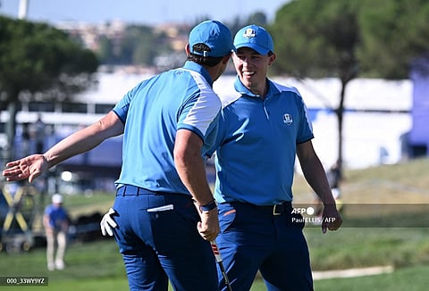 Europe's Northern Irish golfer, Rory McIlroy (L) celebrates with Europe's English golfer, Matt Fitzpatrick after sinking a putt on the 10th green during his four-ball match on the first day of play in the 44th Ryder Cup at the Marco Simone Golf and Country Club in Rome on September 29, 2023. (Photo by Paul ELLIS / AFP)