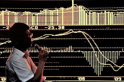 FILE PHOTO: A speaker addresses Chinese investors in front of screens showing stock indexes at a trading house in Shanghai on 25 September 2009. China called on the US on 24 September to ensure the stability of the weak US dollar, saying it was critical to global recovery driven by trade in the key reserve currency. (Photo by PHILIPPE LOPEZ / AFP)