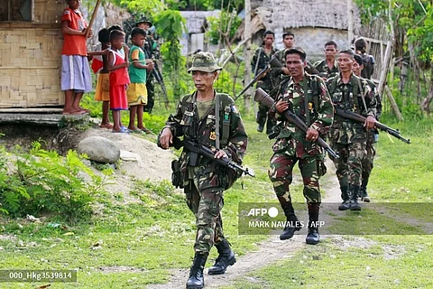 FILE PHOTO: Members of Civilian Armed Forces Geographical Unit (CAFGU) patrol a village in the Philippines. (Photo by MARK NAVALES / AFP)