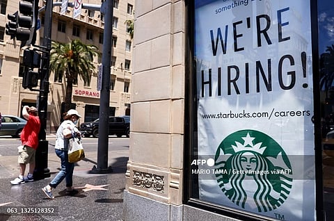 FILE PHOTO: A 'We're Hiring!' sign is displayed at a Starbucks on Hollywood Boulevard in Los Angeles, California. (Photo by MARIO TAMA / GETTY IMAGES NORTH AMERICA / Getty Images via AFP)