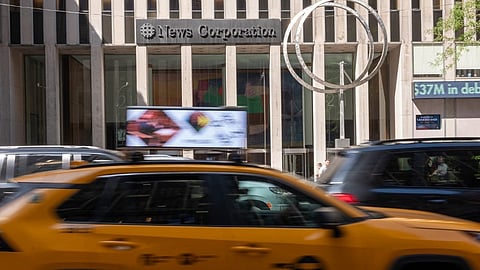 People walk by the News Corp. headquarters in midtown Manhattan on 21 September 2023 in New York City. Rupert Murdoch has announced that he is stepping down as chairman of the board of both Fox Corp. and News Corp. and will be handing control over to his son Lachlan Murdoch, who will become sole chairman of News Corp. and will continue as the CEO of Fox Corp. Murdoch, 92, will be appointed chairman emeritus of each company and act as an adviser to his son. (Photo by SPENCER PLATT / GETTY IMAGES NORTH AMERICA / Getty Images via AFP)