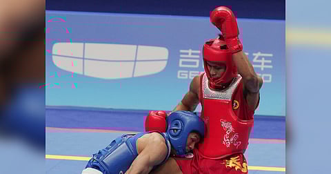 ARNEL Mandal of the Philippines (red) battles Jiang Haidong of China (blue) in the final of the men’s 56-kilogram class sanda competition of the 19th Asian Games. Mandal settled for the silver medal after absorbing a 0-2 setback. | PHOTOGRAPH COURTESY OF PSC-POC MEDIA POOL