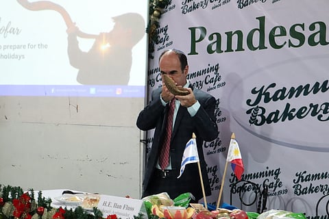 Photograph courtesy of Israel in the Philippines
Israel Ambassador to the Philippines Ilan Fluss blows a tune close to reveille with a ram horn, a custom in Israeli synagogues, at an event on the runup to Jewish New Year.