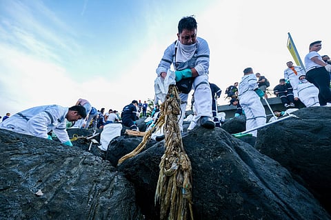 Various private and public sector groups and individuals engage in International Coastal Cleanup Day by collecting washed-up trash along the coast of Manila Bay at the mall bay area in Pasay City on Saturday, 16 September. Photo by KING RODRIGUEZ.