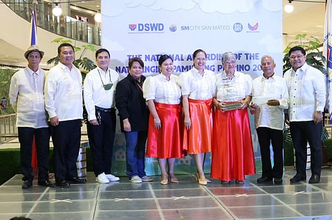 Department of Social Welfare and Development Undersecretary for Policy and Plans Adonis Sulit (right), together with the members of the National Committee on the Filipino Family, presents a plaque of recognition and cash prize to Delgado family for winning the 2023 Natatanging Pamilyang Pilipino on Friday (29 September).
