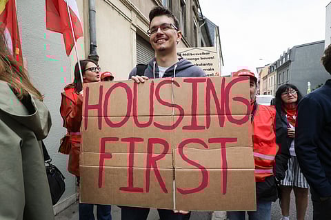 A protestor holds a placard which reads 'Housing First' during a 'Faites du Logement' event organised by the Wunnrech coalition in Luxembourg on 23 September 2023. (Photo by Simon Wohlfahrt / AFP)