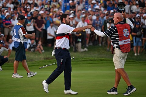 US golfer, Patrick Cantlay (C) celebrates with his caddie Joe LaCava (R) after holing his birdie putt to win the hole and the match on the 18th green with US golfer, Wyndham Clark during their four-ball match against Europe's Northern Irish golfer, Rory McIlroy and Europe's English golfer, Matt Fitzpatrick on the second day of play in the 44th Ryder Cup at the Marco Simone Golf and Country Club in Rome on 30 September 2023. (AFP)