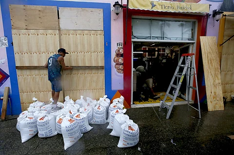 Shopkeepers take precautions by protecting store entrances with sandbags in Puerto Vallarta, Jalisco State, Mexico, on 10 October 2023, ahead of the arrival of Hurricane Lidia to Mexico's Pacific coast. 'Extremely dangerous' Hurricane Lidia makes landfall in Mexico according to the US National Hurricane Center. (Photo by Ulises RUIZ / AFP)