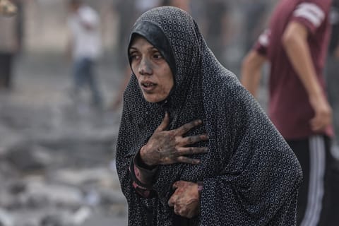 A Palestinian woman covered in dust, reacts following an Israeli airstrike on buildings in Rafah, in the southern Gaza Strip on October 17, 2023, amid the ongoing battles between Israel and the Palestinian group Hamas. Photo by MOHAMMED ABED / AFP